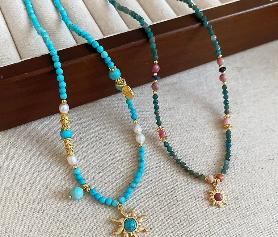French royal style necklace with sun pendant, freshwater pearls, and adjustable metal chain.