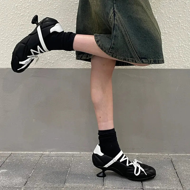 Women's silver lace-up sports shoes with a bow detail on the front, showing a low-top and round toe design.