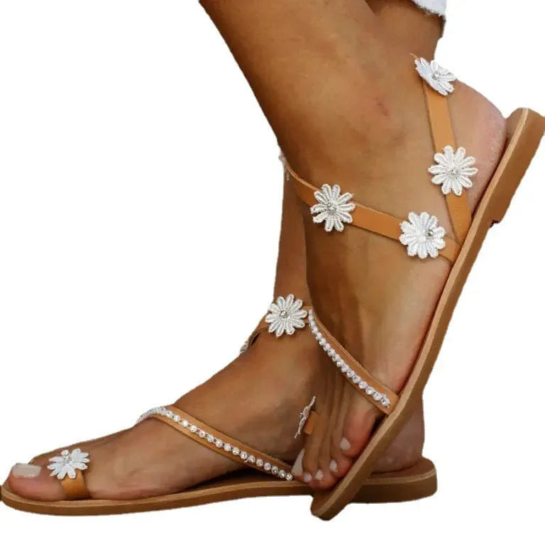 Brown women's flat Roman sandals with floral ethnic pattern and herringbone toe design on rubber sole.