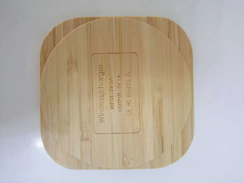 Square wooden bamboo 5W Qi wireless charging pad on a desk.