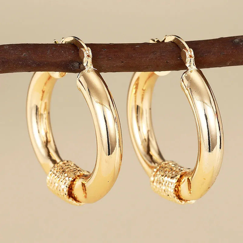 Geometric women's copper earrings with ring and line details in a gold colour.