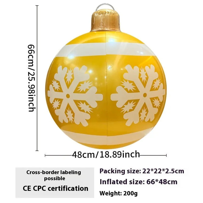 Large red and white inflatable Christmas ball with snowflake design in garden setting