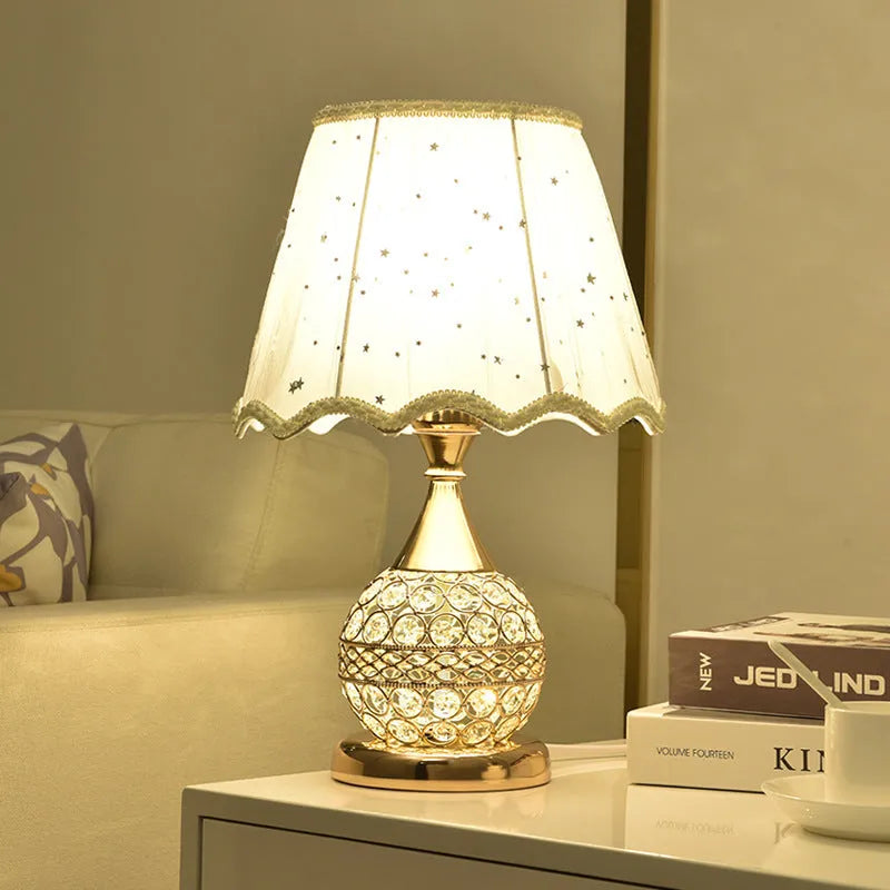 Gold crystal desk lamp with iron art base and remote control on wooden surface