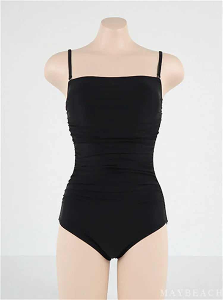Blue sling style one-piece swimsuit with belly pleating on a mannequin