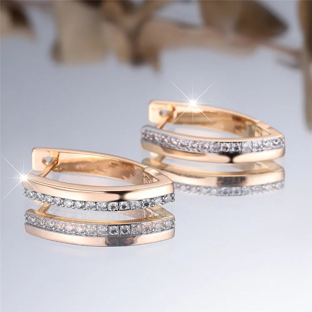 Women's geometric drop earrings with champagne gold electroplating and white diamond accents, showing V-shaped design and clip-on back.