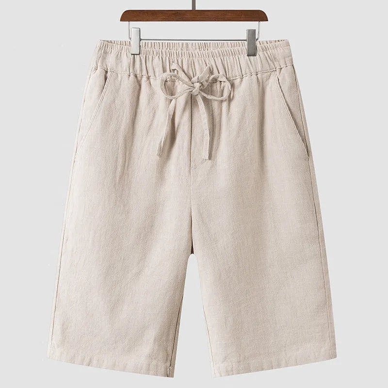 Man wearing beige linen cropped shorts with a loose fit and elasticated waist