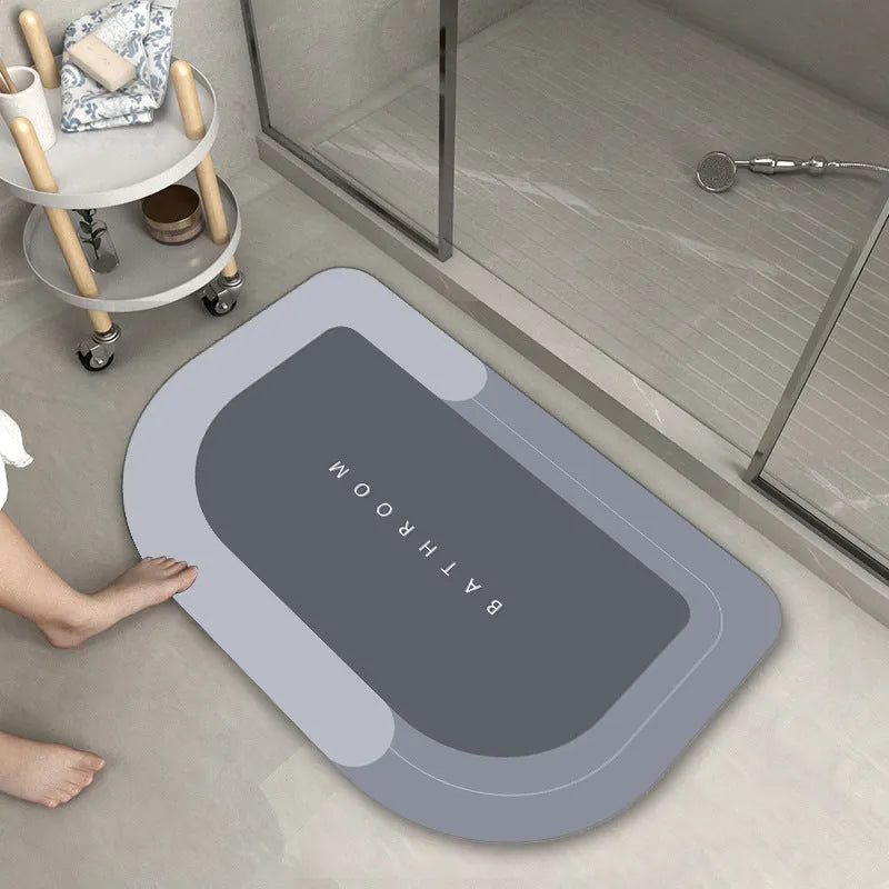 Soft blue oval bathroom floor mat placed on tiles beside a bathtub.
