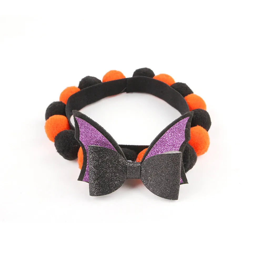 Halloween dog collar with a large orange pom-pom and pumpkin design on an adjustable black band.