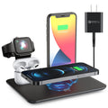 Black and white wireless charging station for phone, smartwatch, and headphones on a desk.