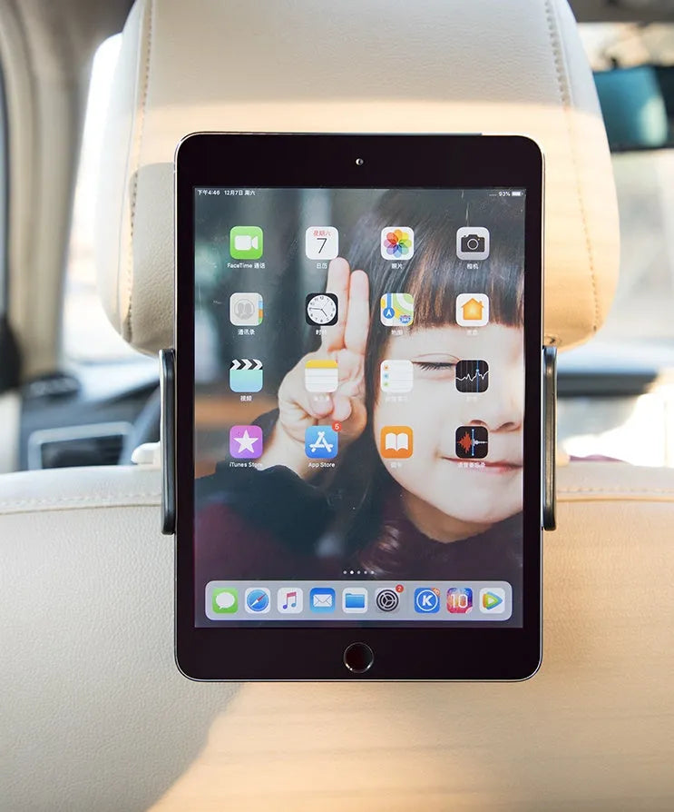 Black car phone holder mounted on vehicle rear seat base with tablet device secured in place