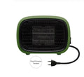 Compact green portable ceramic fan heater with metal grille, shown on a desk