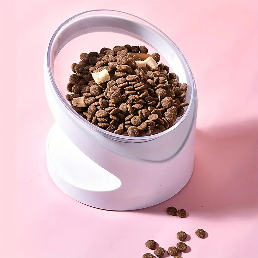 Clear plastic tilted cat food bowl on a flat surface