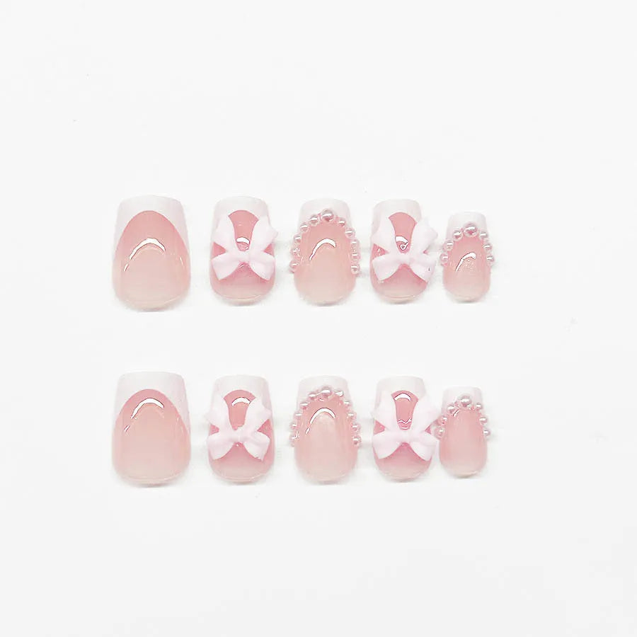 Set of short white French style press-on nail stickers with cute bow and tulip designs.