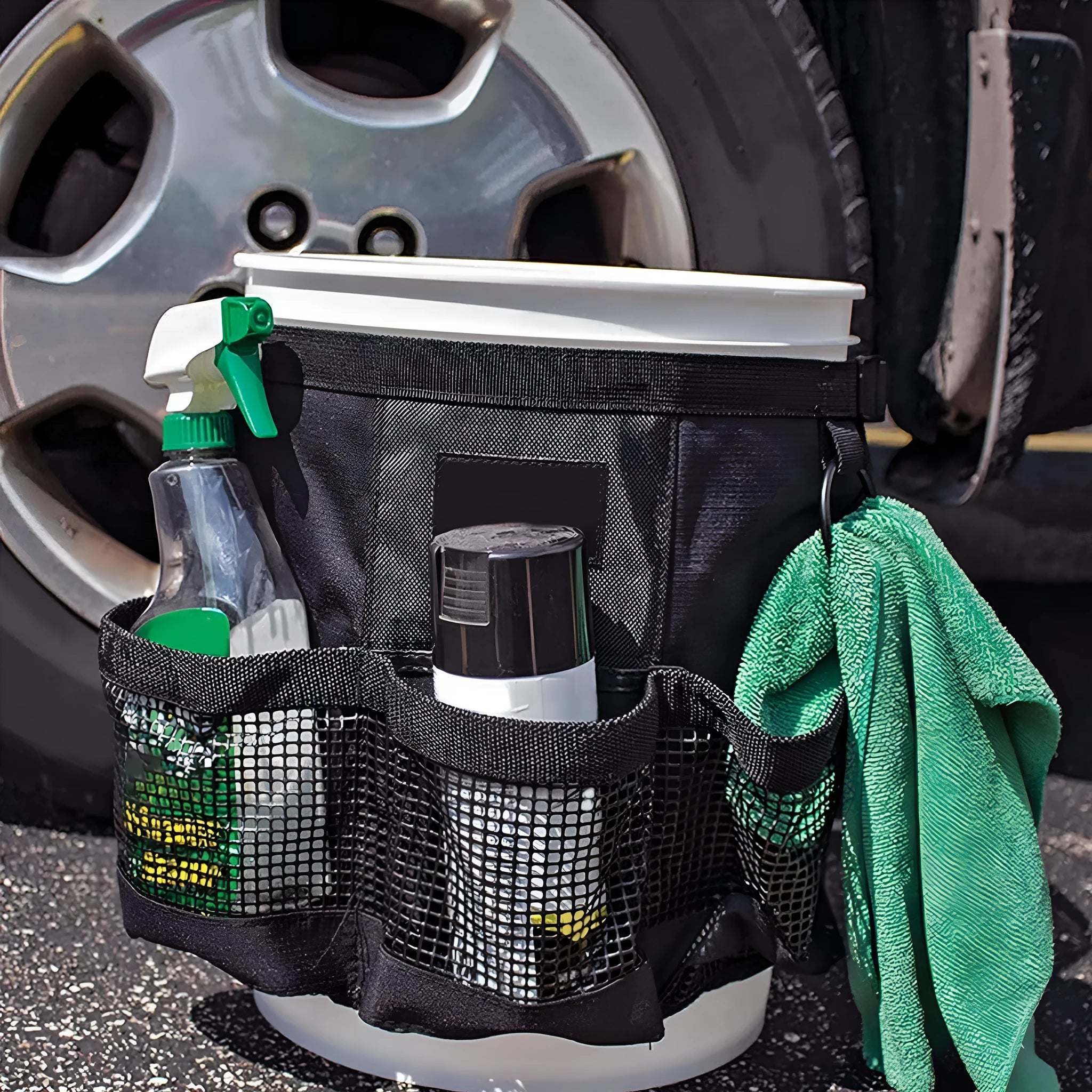 Black cylindrical polyester storage bag hanging on a 5 gallon barrel for car washing tools and outdoor gear.
