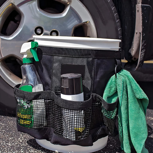 Black cylindrical polyester storage bag hanging on a 5 gallon barrel for car washing tools and outdoor gear.