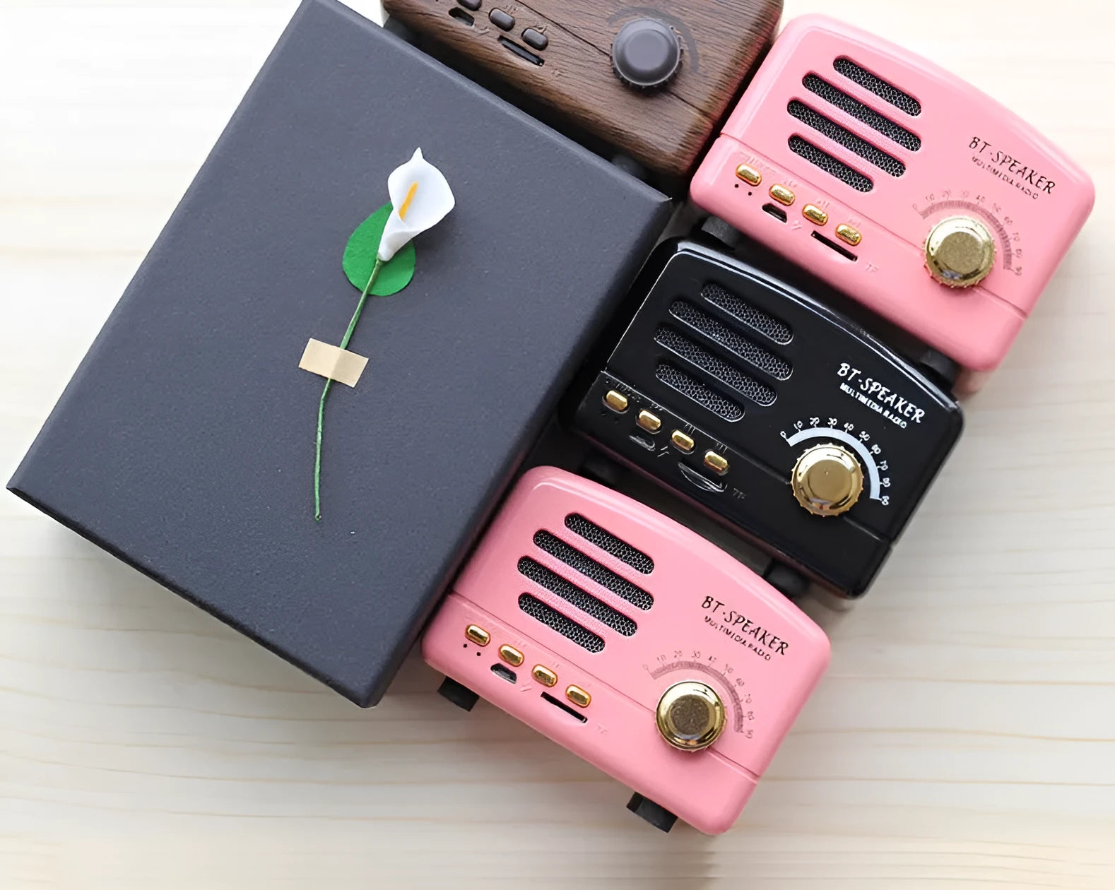 Vintage wood Bluetooth speaker in pink, black, and wood grain colours showing compact 93x70x59mm dimensions