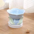 Blue ceramic elevated pet bowl with floral pattern and non-slip base for cats or small dogs.