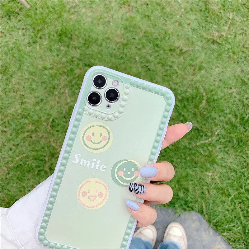 Green iPhone case with geometric shapes and smiley face pattern, TPU back cover.