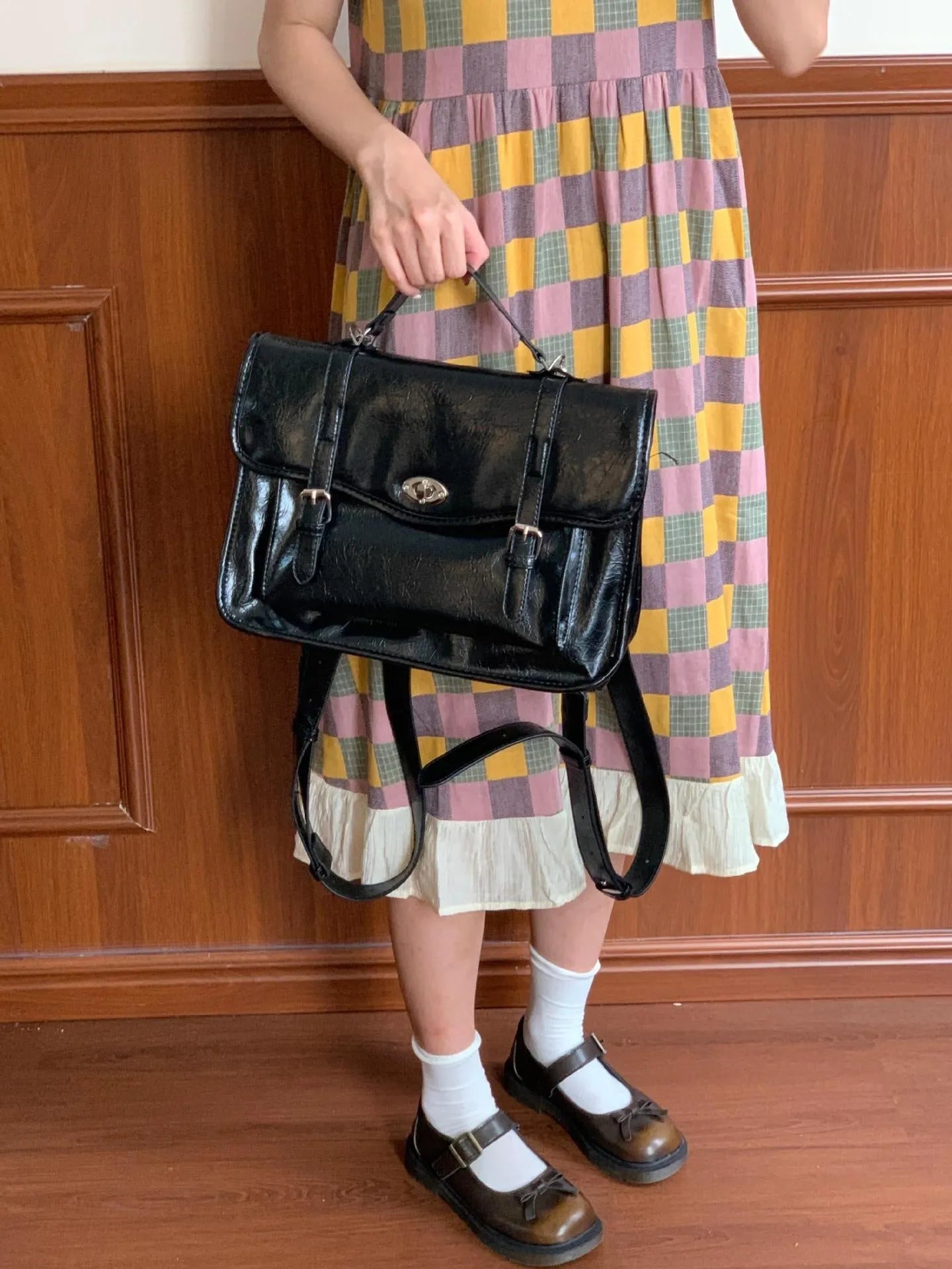 Black women's messenger bag with oil wax leather finish and adjustable crossbody strap
