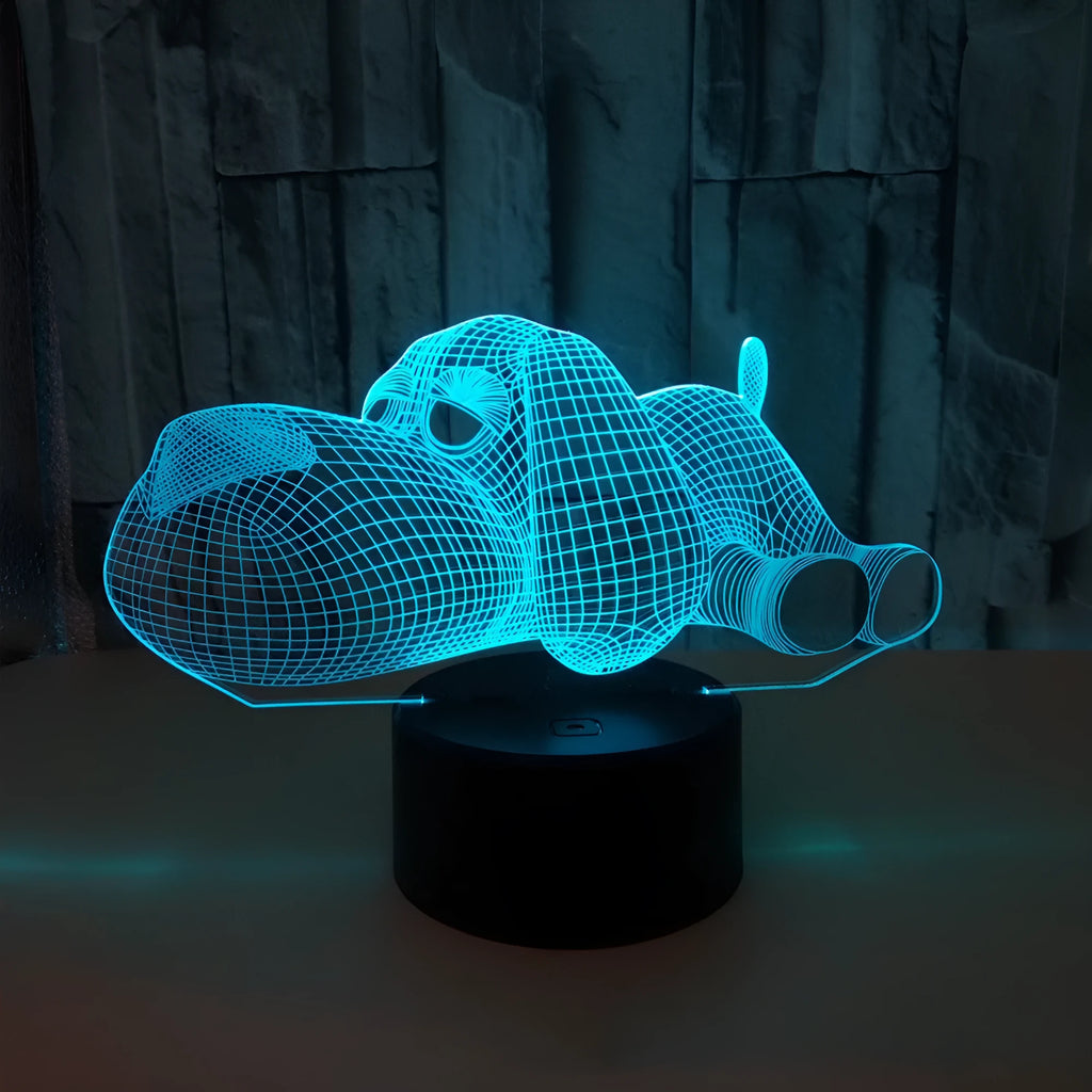 Dog-shaped 3D desktop lamp glowing in multiple colours on a wooden surface.