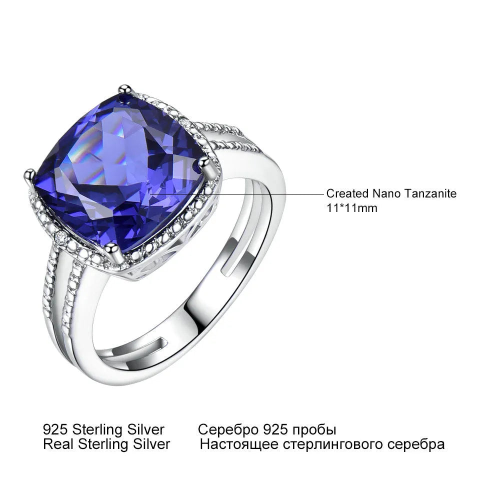Blue tanzanite stone set in a sterling silver women's ring on a finger.