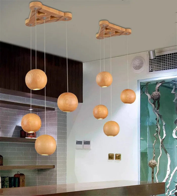 Nordic solid wood ball chandelier pendant light with wooden shade, shown in a living room setting.