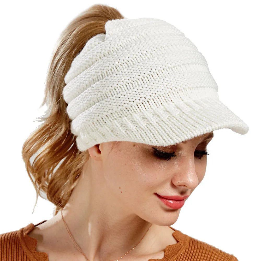 Women's acrylic knitted ponytail beanie hat in beige colour on a model.