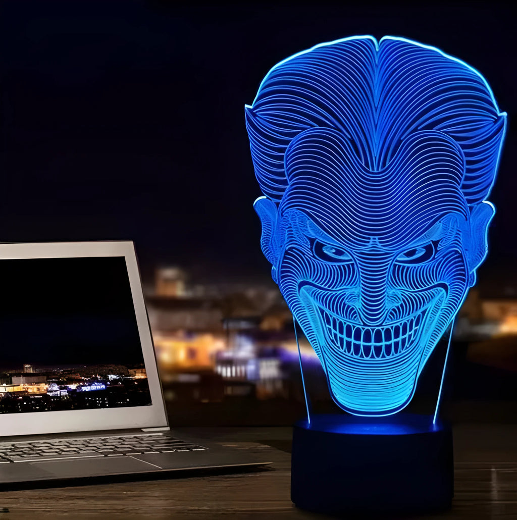 A clear acrylic 3D LED table lamp displaying gradient colours, standing on a square base with a USB cable and remote control.