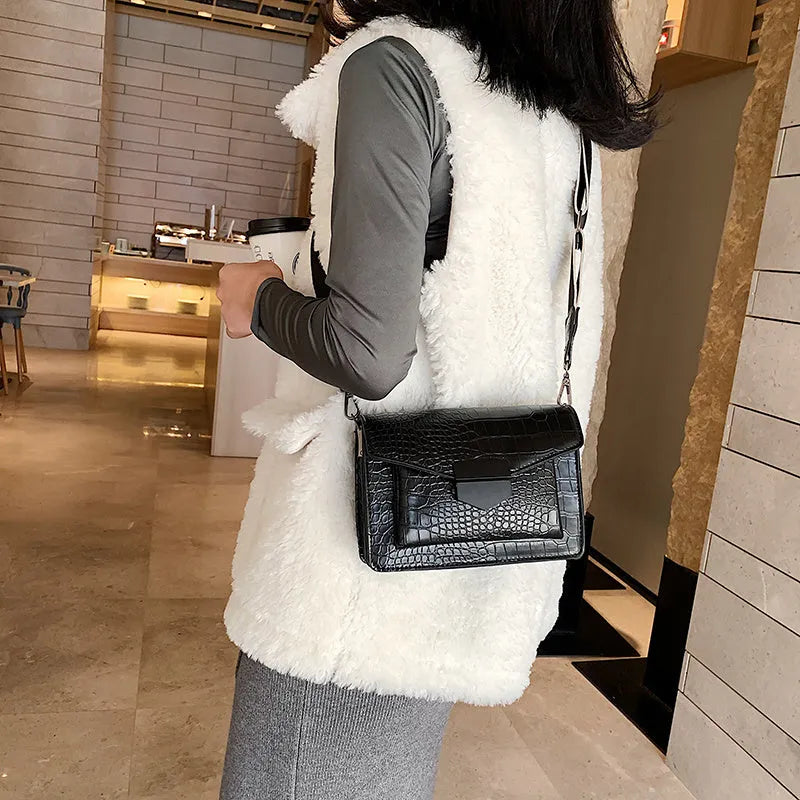 Vintage PU crossbody bag in black, shown with adjustable strap and open to reveal polyester lining.