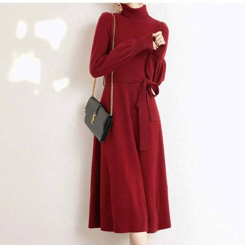 Loose-fitting turtleneck knit dress in rose red with long sleeves and a mid-length skirt.