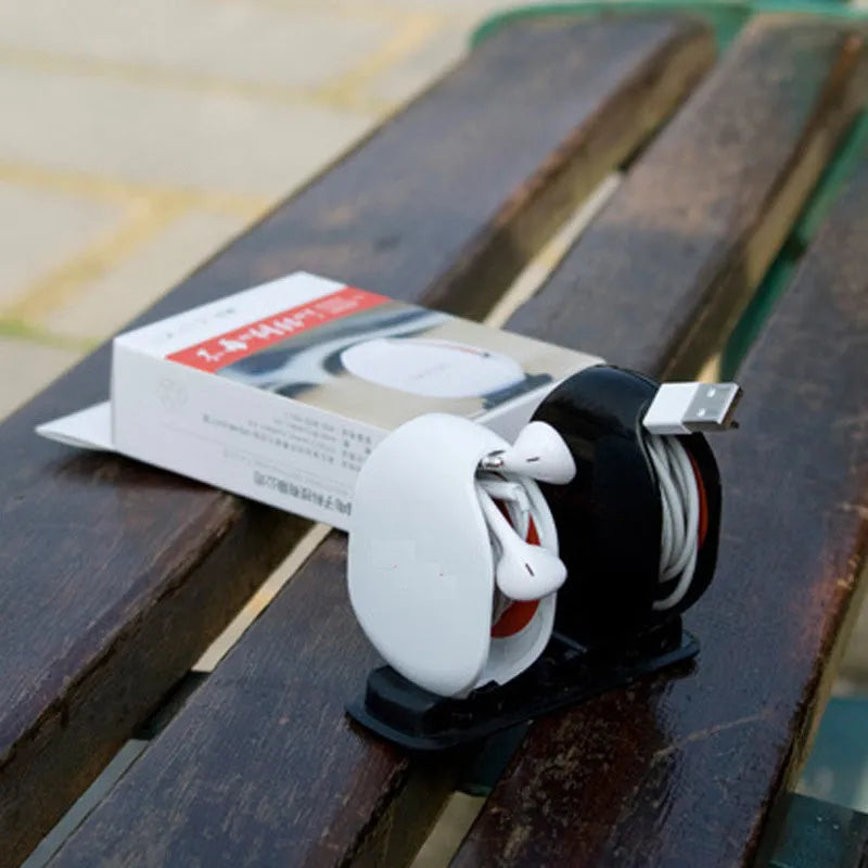 Automatic push-button earphone cable winder reel in assorted colours on a white background.