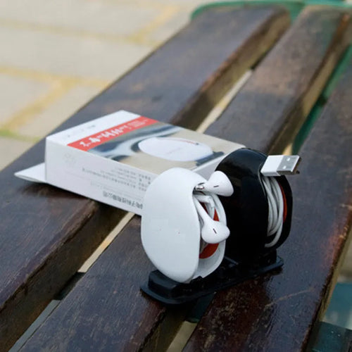 Automatic push-button earphone cable winder reel in assorted colours on a white background.