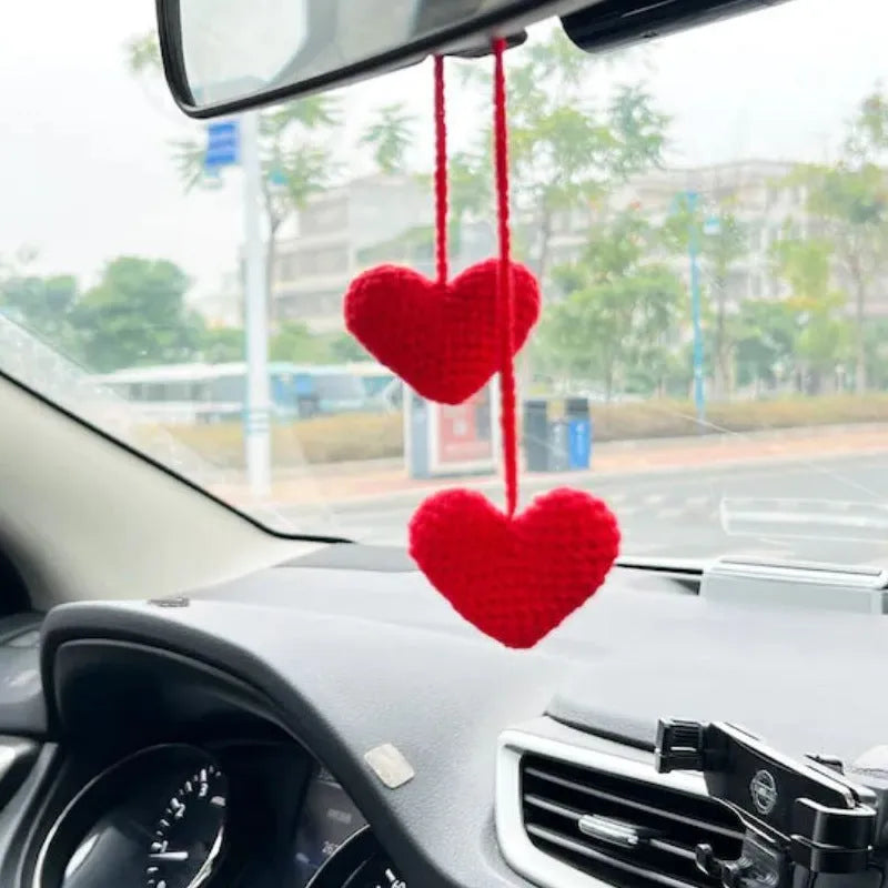 Green and white knitted wool car plant decoration with white hanging rope.