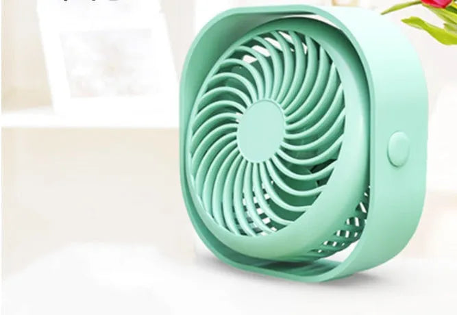 USB desk fan with rotating head in modern alarm clock style on a desk.