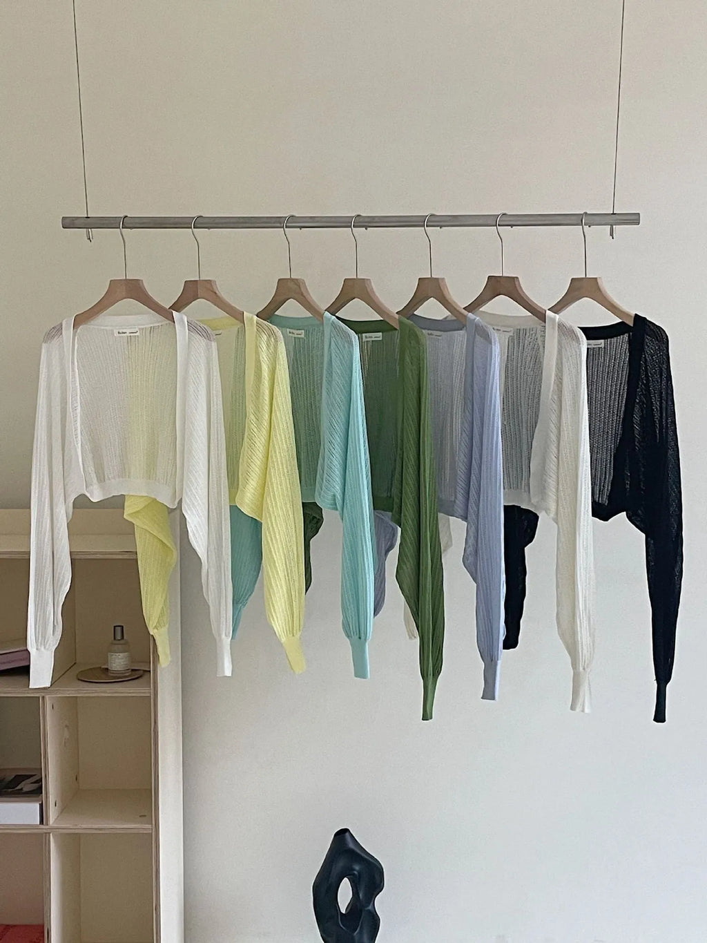 Thin loose linen blouse with hollow out lantern sleeves in apricot colour on a hanger.