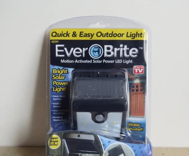 Four white solar-powered LED sensor lights for outdoor wall or garden installation.