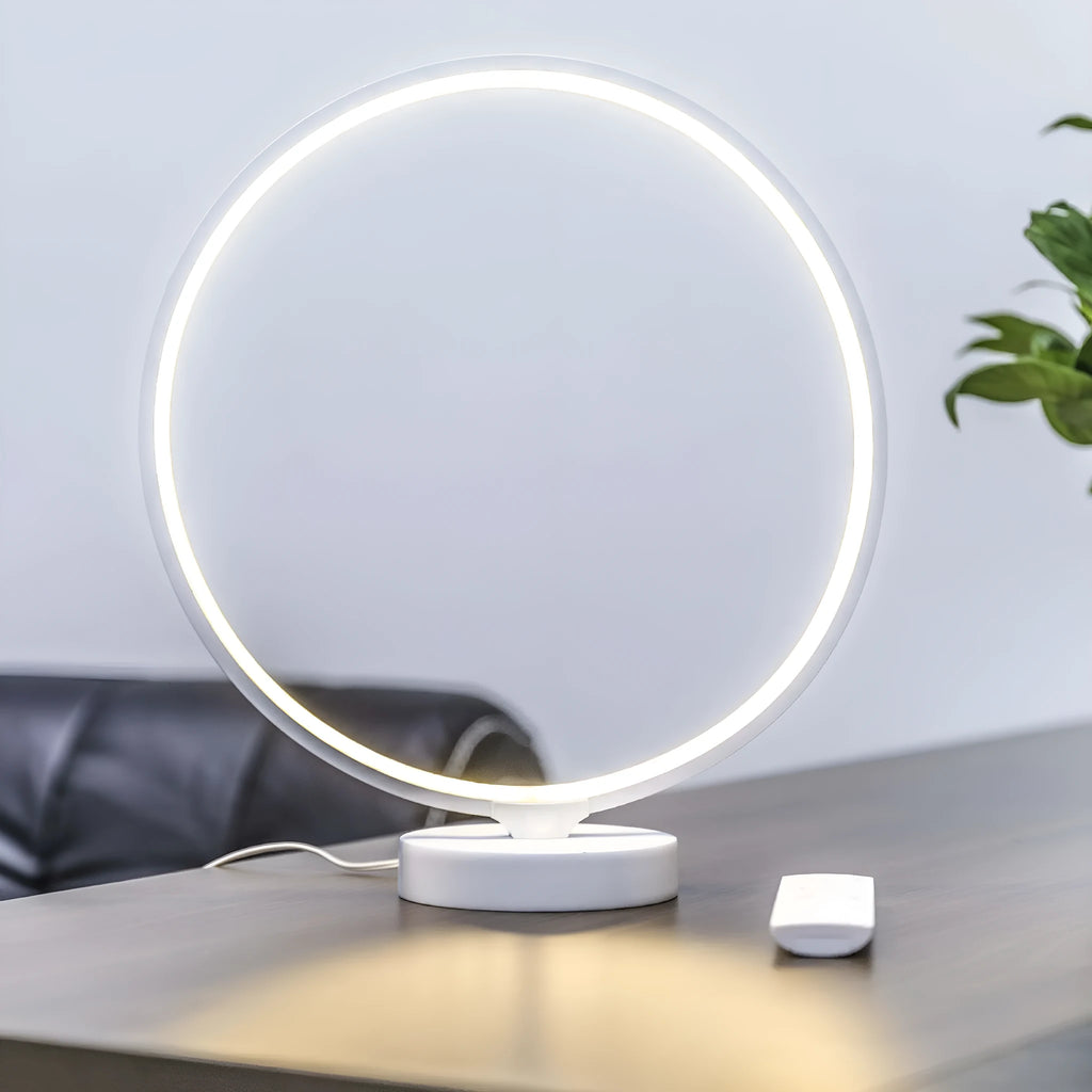 White Full Moon shaped table lamp with LED lighting and a remote control on a table.
