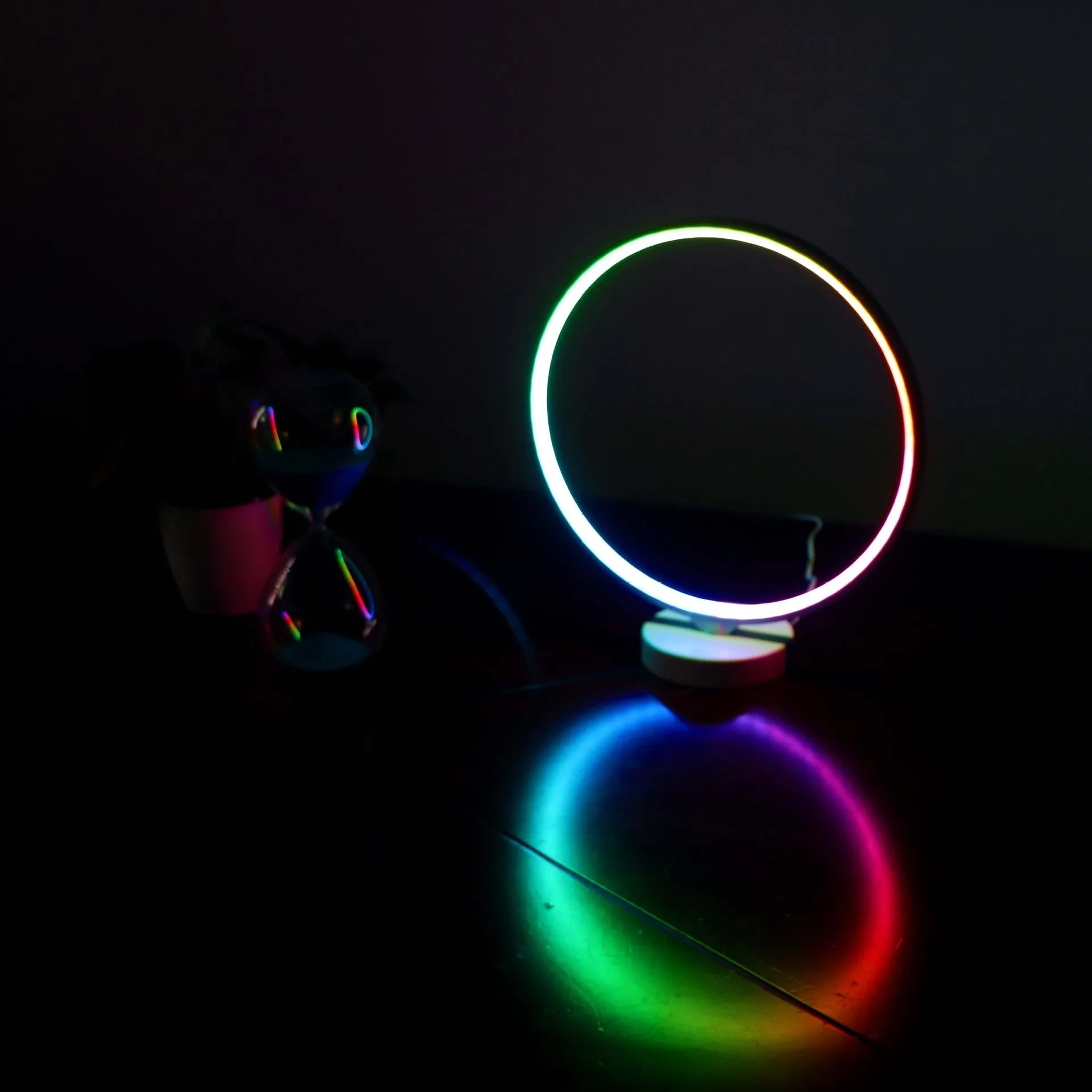 White Full Moon shaped table lamp with LED lighting and a remote control on a table.