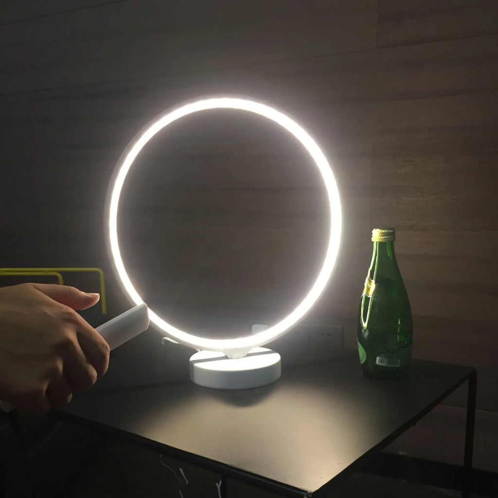 White Full Moon shaped table lamp with LED lighting and a remote control on a table.