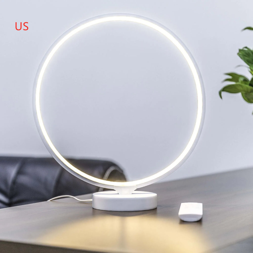 White Full Moon shaped table lamp with LED lighting and a remote control on a table.