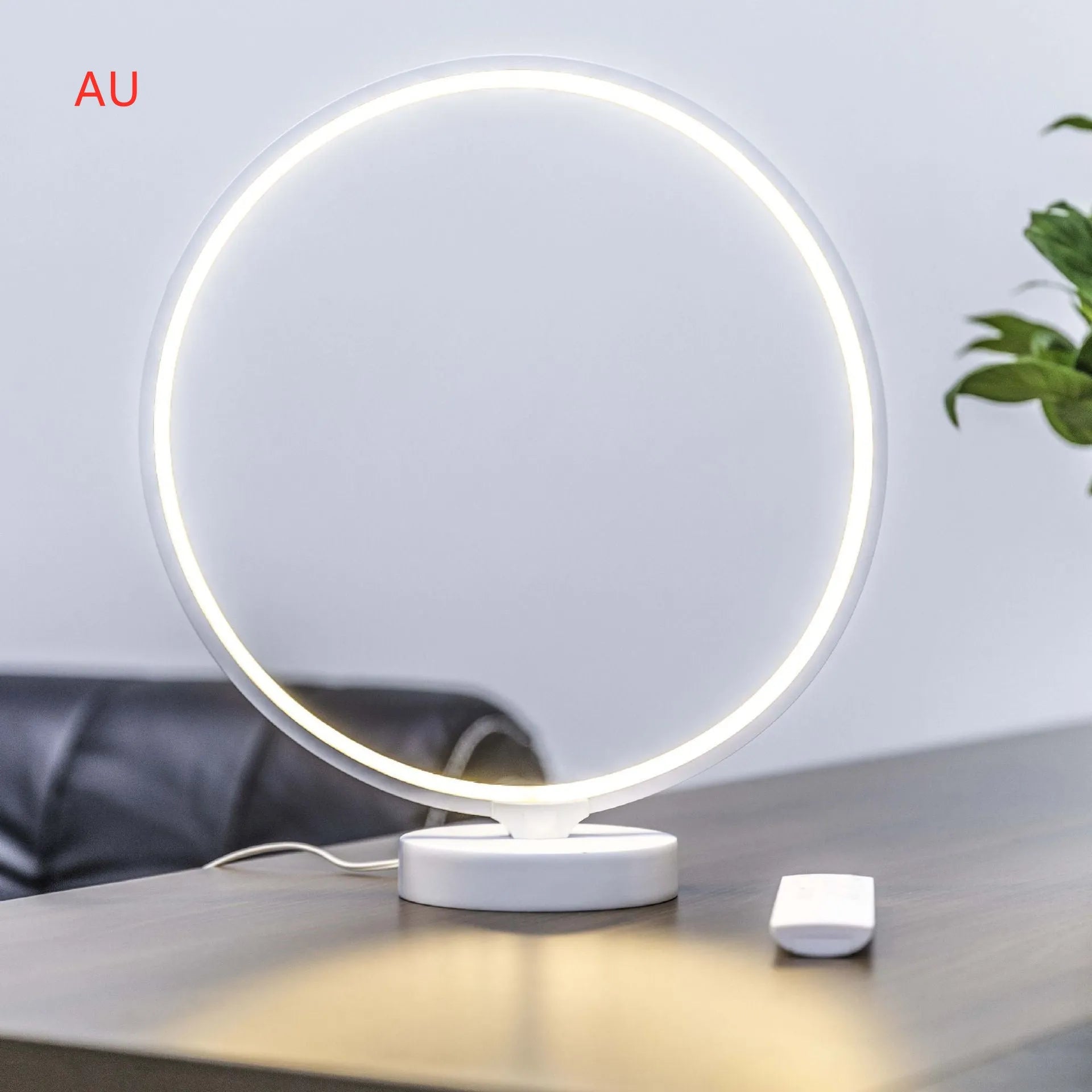 White Full Moon shaped table lamp with LED lighting and a remote control on a table.