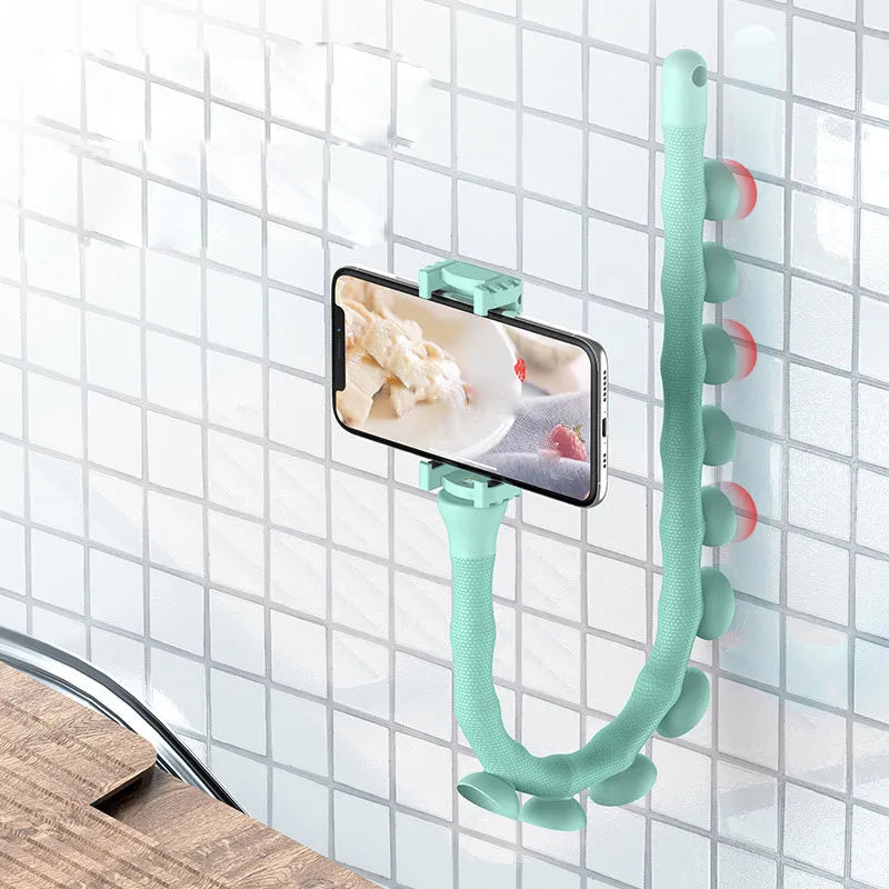 Flexible rubber phone holder with suction cup mounted on desktop showing 360-degree rotation