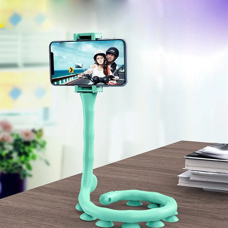 Flexible rubber phone holder with suction cup mounted on desktop showing 360-degree rotation