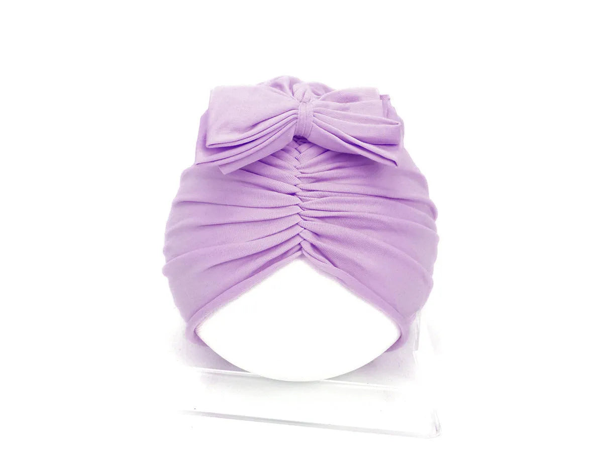 Soft acrylic knitted baby hat in a solid colour, shown stretched to demonstrate fit.