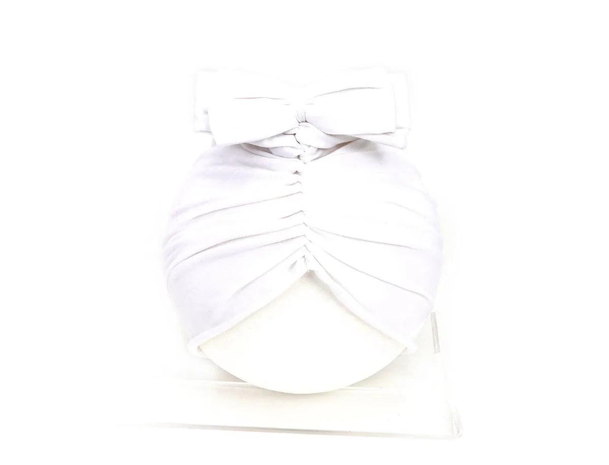 Soft acrylic knitted baby hat in a solid colour, shown stretched to demonstrate fit.