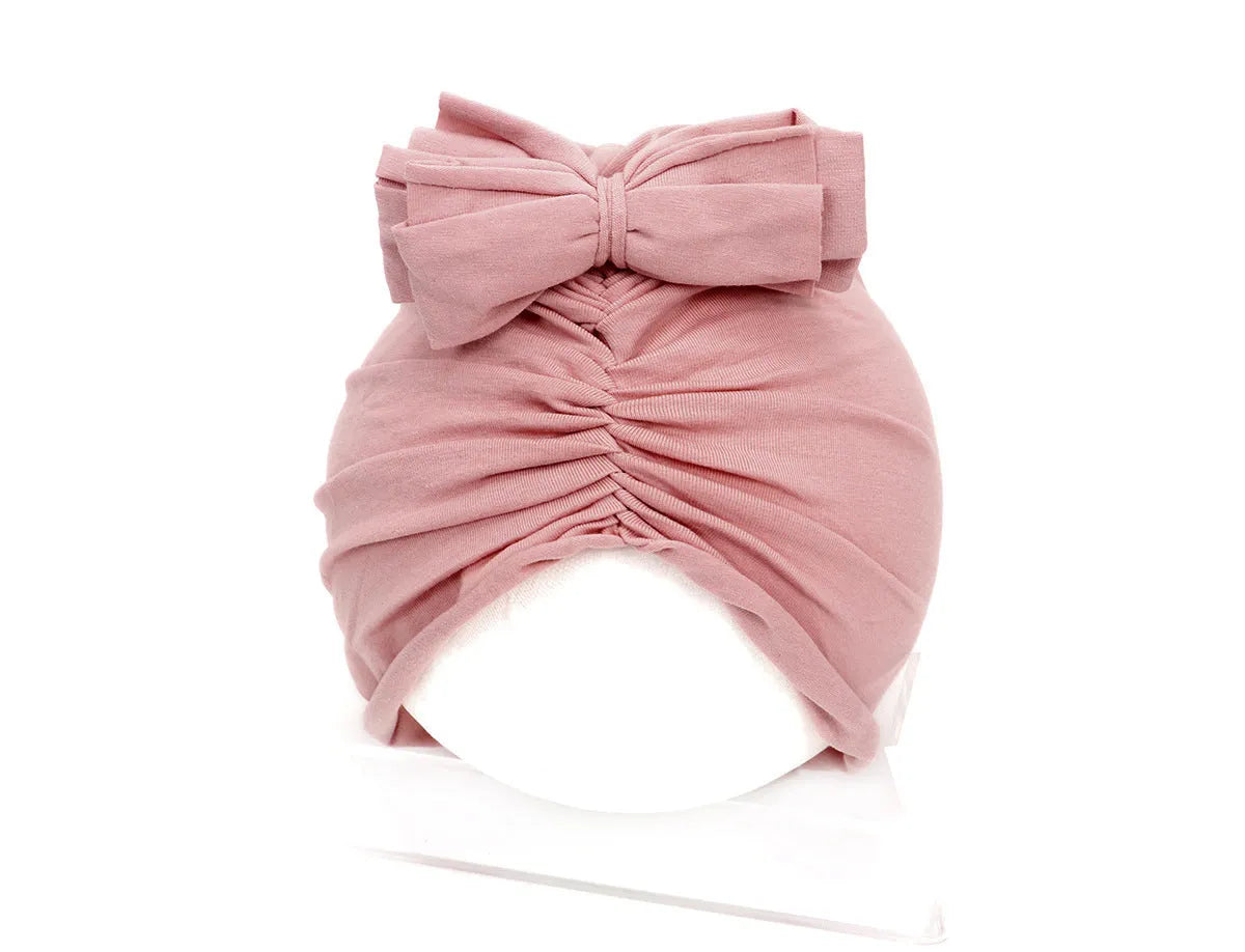 Soft acrylic knitted baby hat in a solid colour, shown stretched to demonstrate fit.