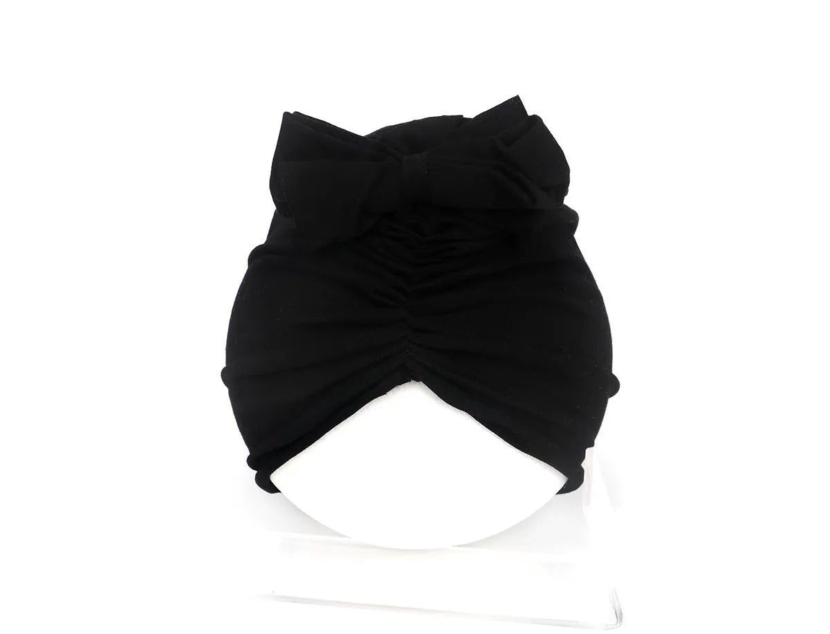 Soft acrylic knitted baby hat in a solid colour, shown stretched to demonstrate fit.
