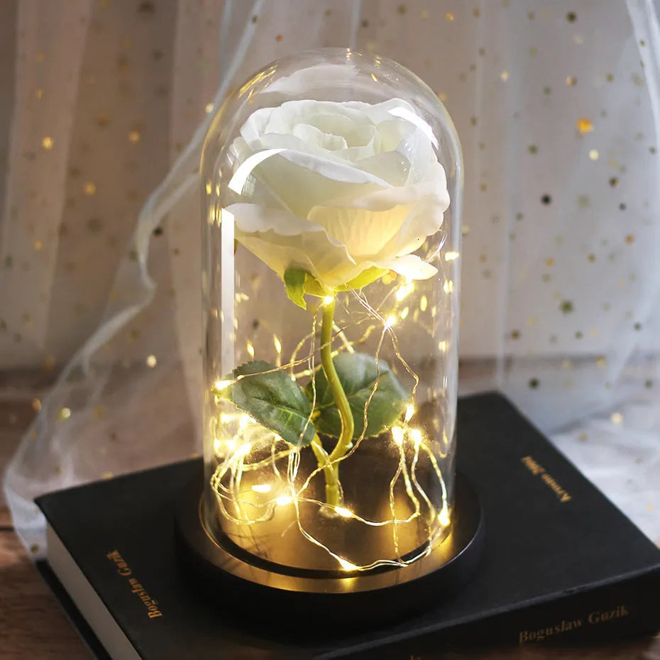 LED rose ornament with silk flowers under glass shade, showing colour options on a wooden base.