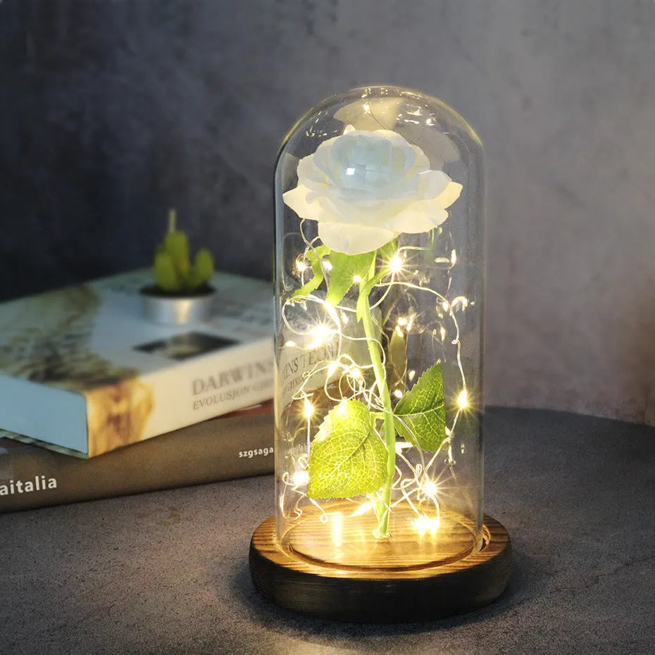LED rose ornament with silk flowers under glass shade, showing colour options on a wooden base.