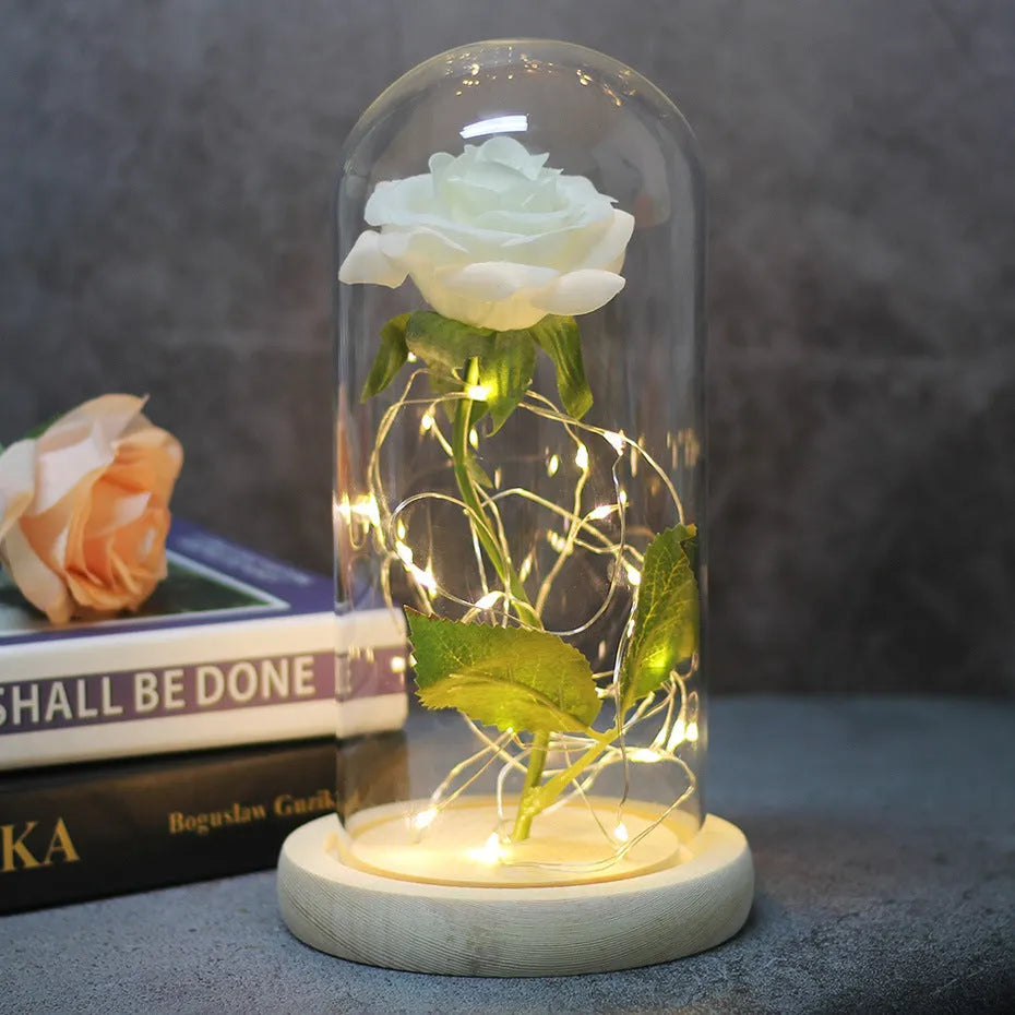 LED rose ornament with silk flowers under glass shade, showing colour options on a wooden base.